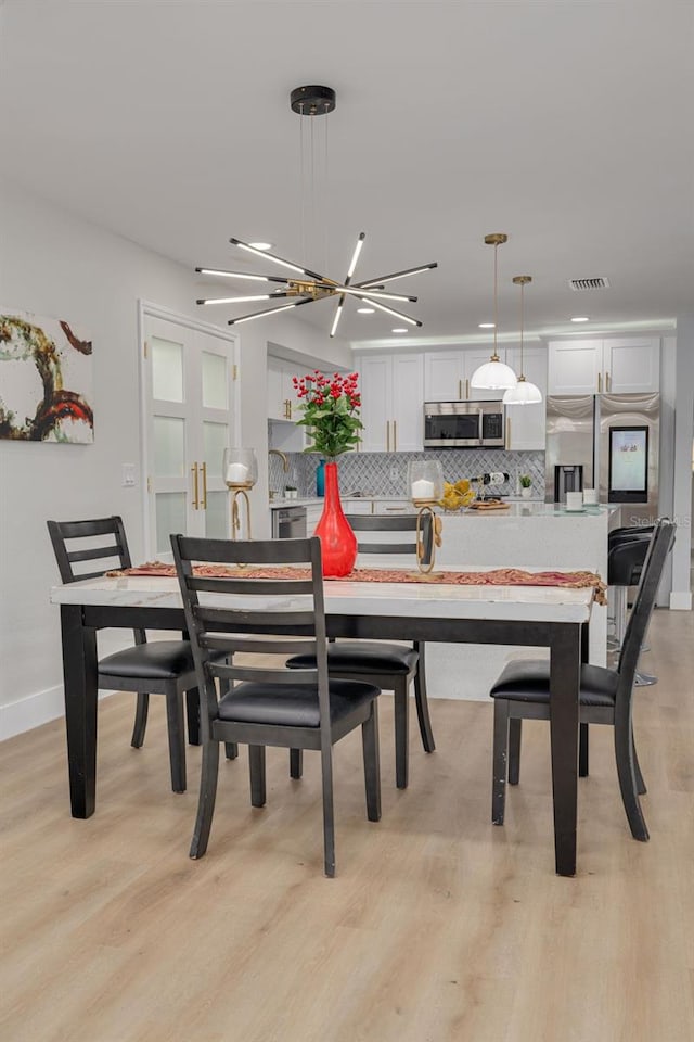 dining space featuring a chandelier and light hardwood / wood-style flooring