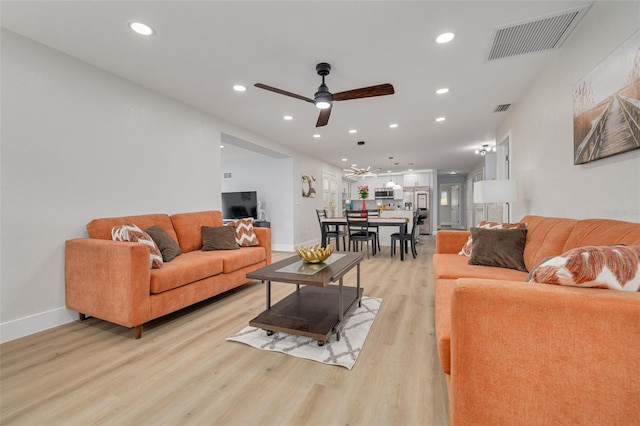 living room featuring ceiling fan and light hardwood / wood-style flooring