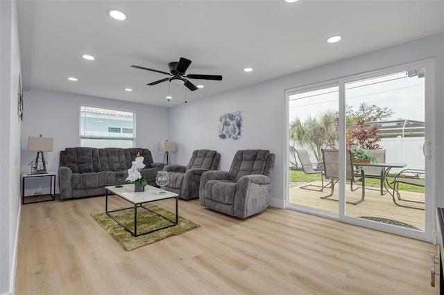 living room with light hardwood / wood-style floors and ceiling fan