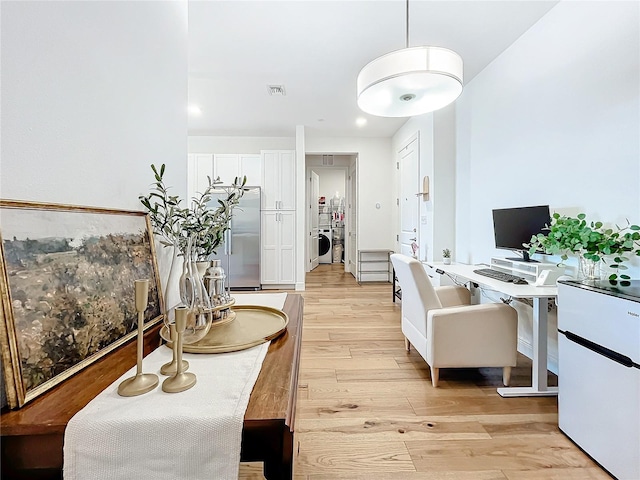 dining area with light hardwood / wood-style flooring and washer / dryer