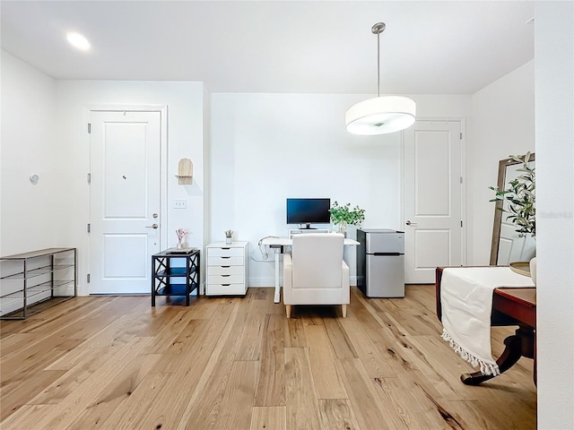 interior space featuring stainless steel fridge and light hardwood / wood-style flooring