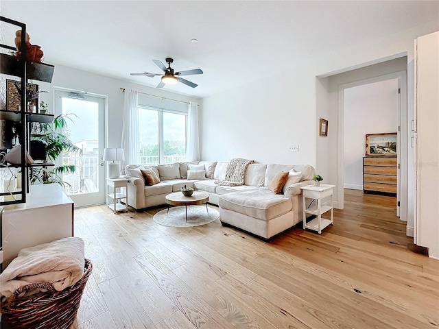 living room with light hardwood / wood-style flooring and ceiling fan