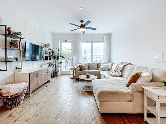 living room featuring light wood-type flooring and ceiling fan