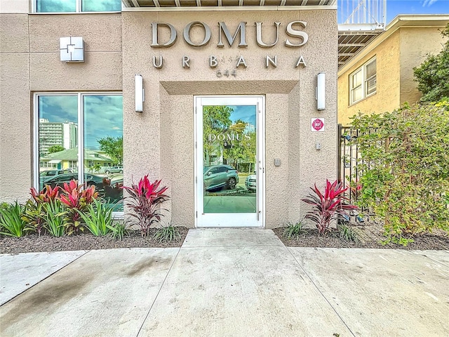 doorway to property featuring stucco siding