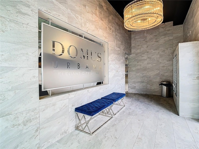 bathroom featuring a notable chandelier and tile walls