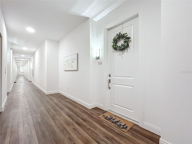 foyer entrance featuring dark wood-style floors and baseboards