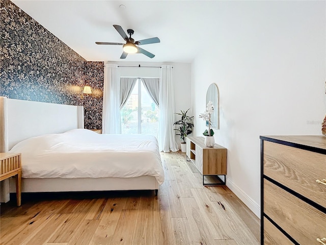 bedroom with ceiling fan, baseboards, and wood finished floors