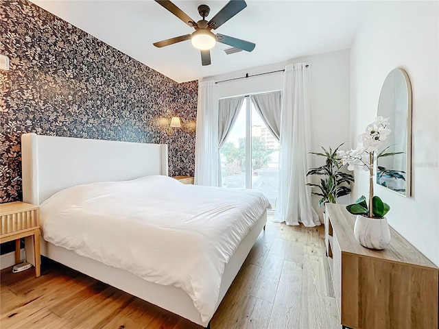 bedroom featuring a ceiling fan, light wood-type flooring, visible vents, and wallpapered walls