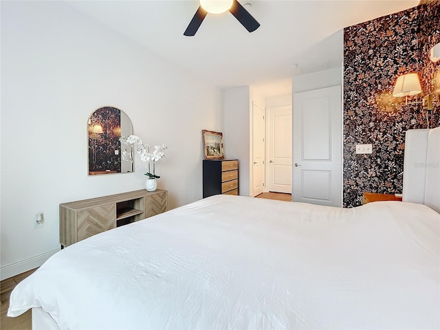 bedroom with a ceiling fan and baseboards