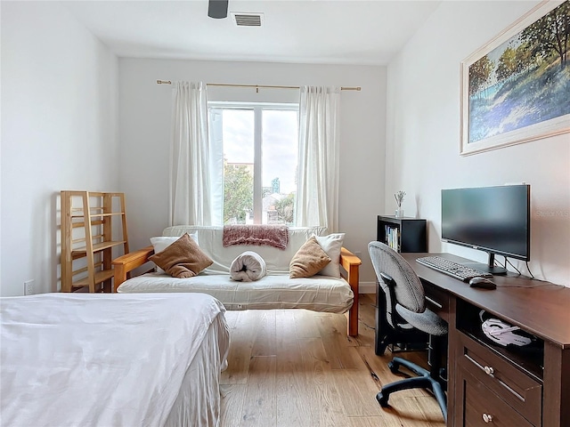 bedroom with light wood finished floors and visible vents