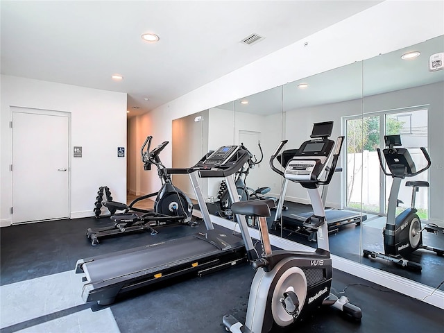 exercise room with baseboards, visible vents, and recessed lighting