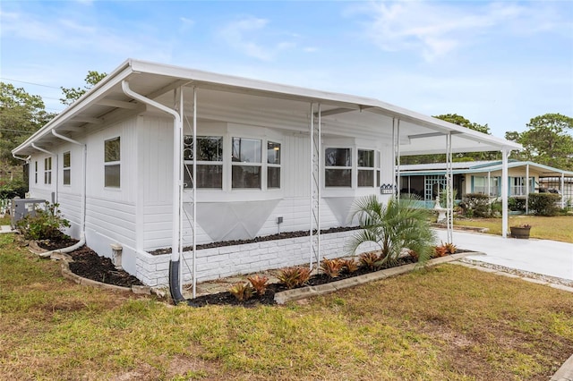 view of home's exterior featuring central AC unit, a carport, and a lawn