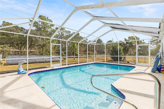 view of pool with glass enclosure and a patio