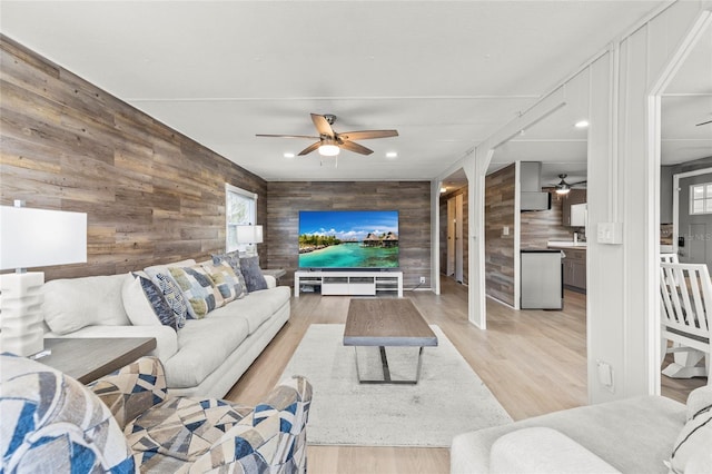 living room with light hardwood / wood-style floors and wood walls