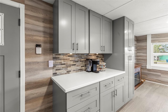 kitchen featuring tasteful backsplash, light hardwood / wood-style flooring, and gray cabinetry