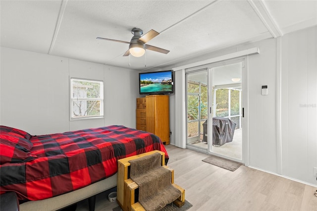 bedroom featuring access to outside, ceiling fan, light hardwood / wood-style flooring, and a textured ceiling