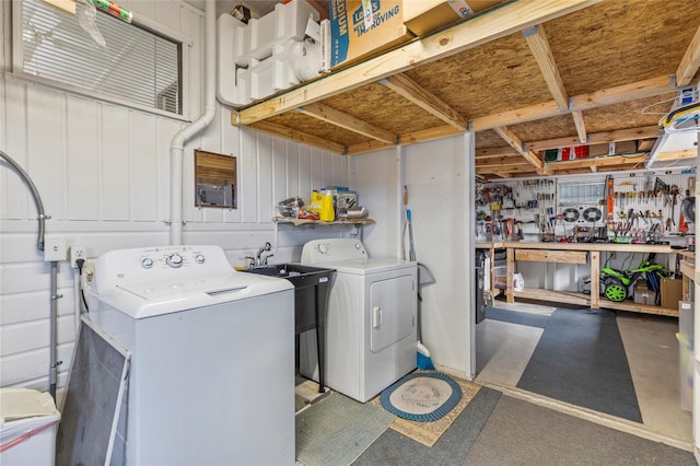 laundry room with independent washer and dryer and a workshop area