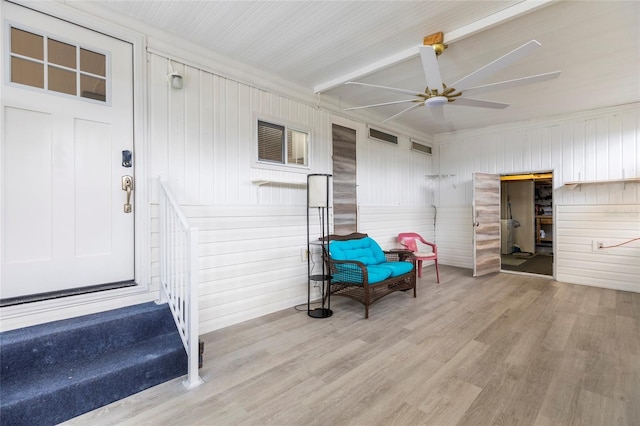 living area featuring beamed ceiling, ceiling fan, light hardwood / wood-style floors, and crown molding