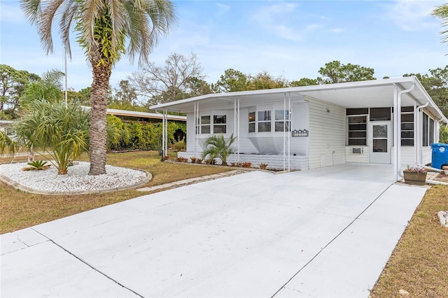 view of front facade with a front lawn, driveway, and an attached carport