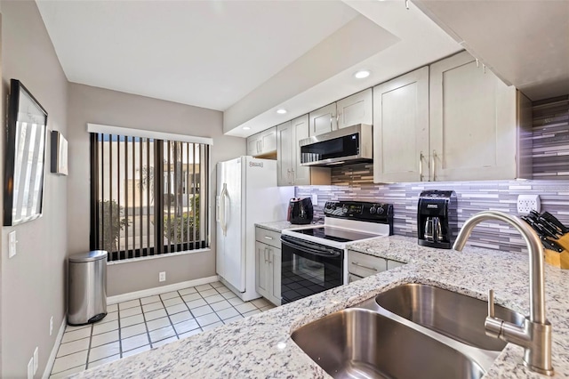 kitchen with light stone counters, light tile patterned flooring, electric stove, and sink