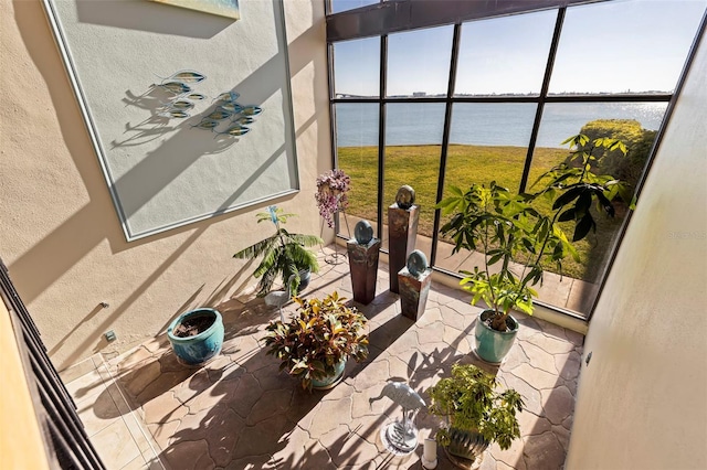 sunroom / solarium featuring a water view