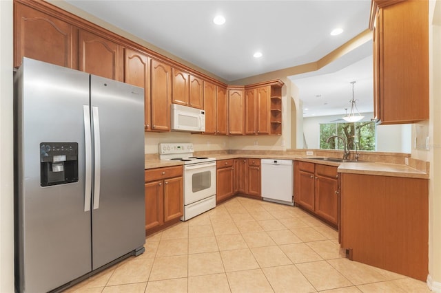 kitchen featuring light tile patterned flooring, white appliances, and sink