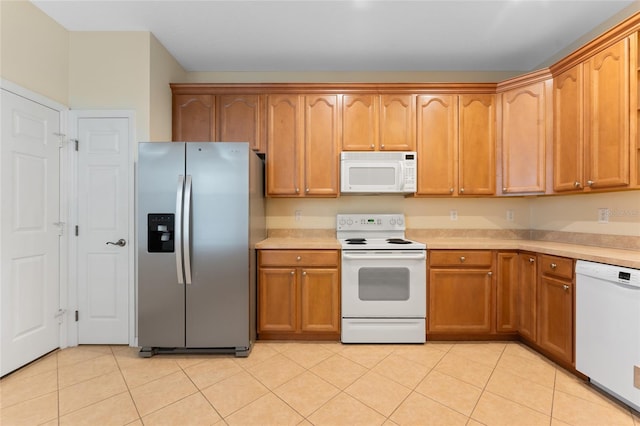 kitchen featuring light tile patterned floors and white appliances