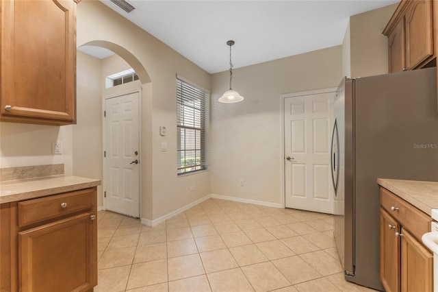 kitchen featuring stainless steel fridge, pendant lighting, and light tile patterned flooring