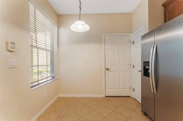 kitchen with decorative light fixtures, light tile patterned floors, and stainless steel refrigerator with ice dispenser