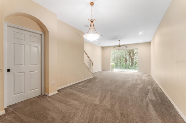 unfurnished room with carpet flooring and ceiling fan