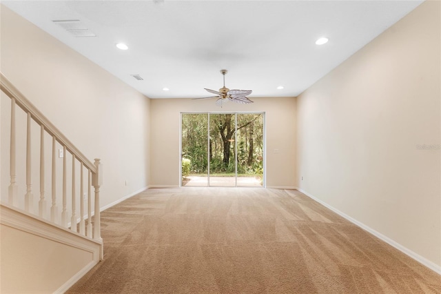 unfurnished living room featuring ceiling fan and light colored carpet