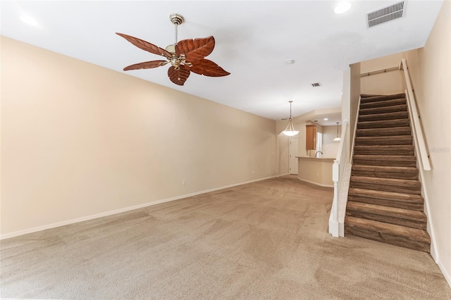 unfurnished living room featuring ceiling fan and light carpet