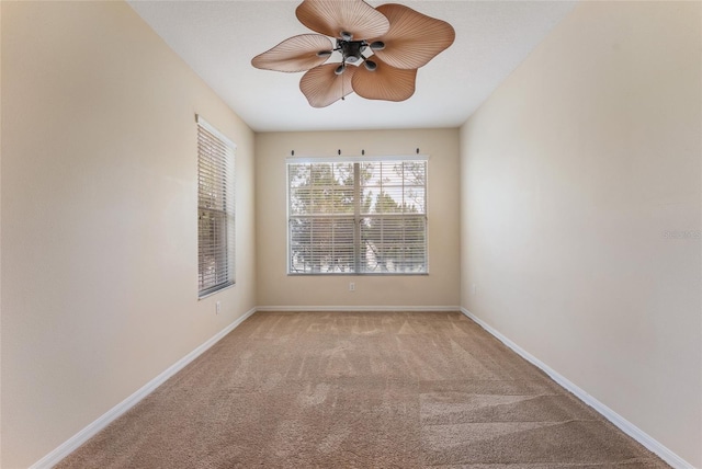 carpeted empty room featuring ceiling fan