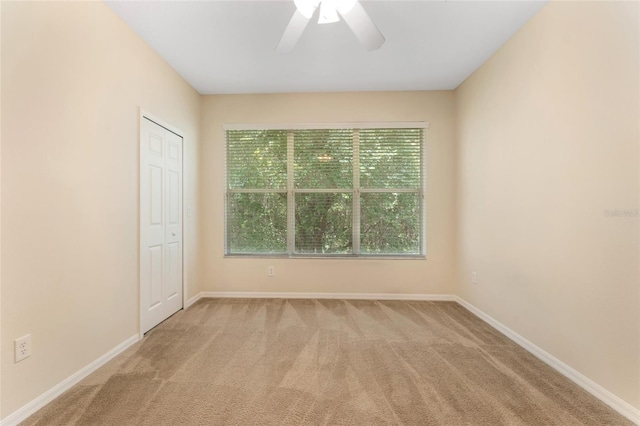 carpeted empty room featuring ceiling fan