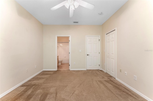 unfurnished bedroom featuring ceiling fan, carpet, and ensuite bathroom