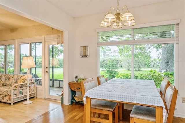 dining space with hardwood / wood-style floors and a chandelier