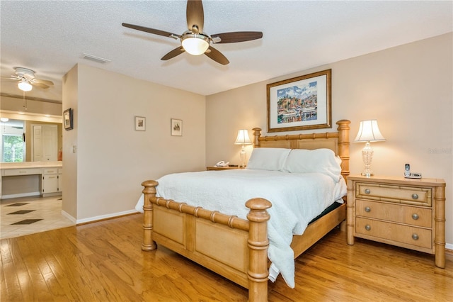 bedroom featuring ceiling fan, light hardwood / wood-style floors, and a textured ceiling