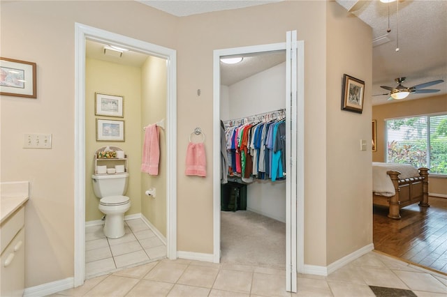 bathroom featuring vanity, tile patterned floors, ceiling fan, toilet, and a textured ceiling