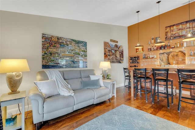 living room with indoor bar, hardwood / wood-style flooring, and lofted ceiling