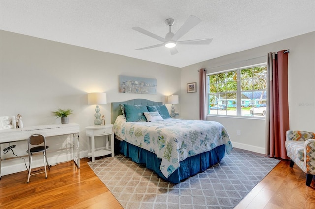 bedroom featuring ceiling fan, a textured ceiling, and hardwood / wood-style flooring