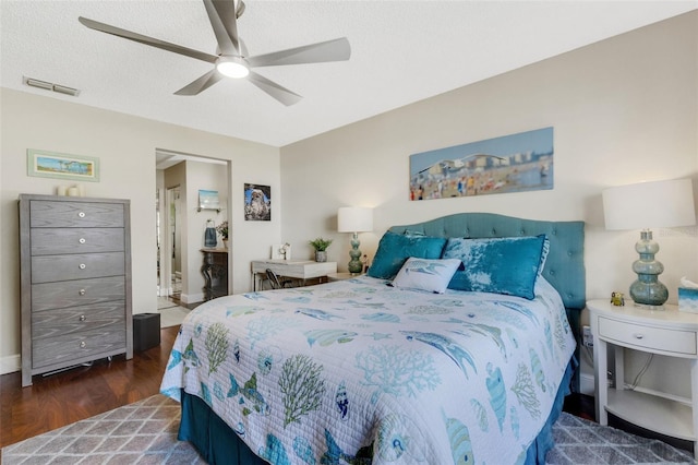 bedroom featuring ceiling fan, dark hardwood / wood-style flooring, and a textured ceiling