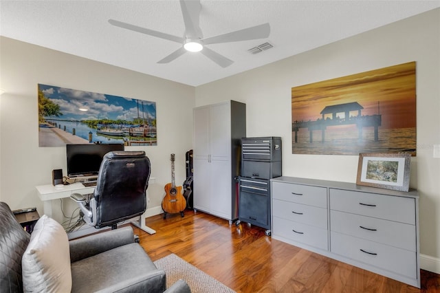 office area featuring ceiling fan, light hardwood / wood-style floors, and a textured ceiling