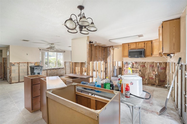 kitchen featuring ceiling fan with notable chandelier