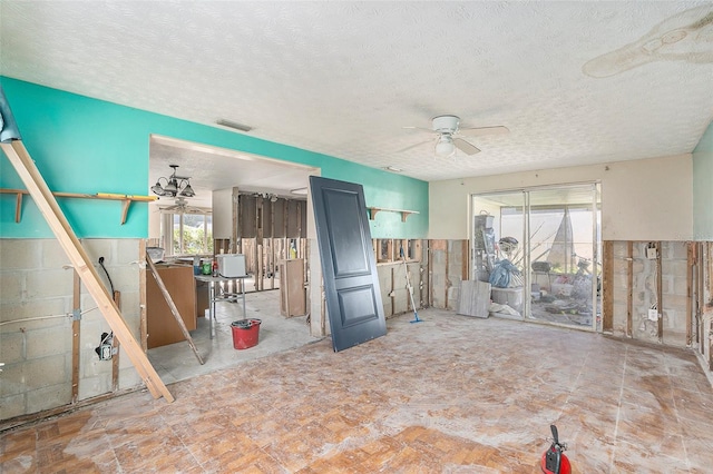 interior space with ceiling fan and a textured ceiling