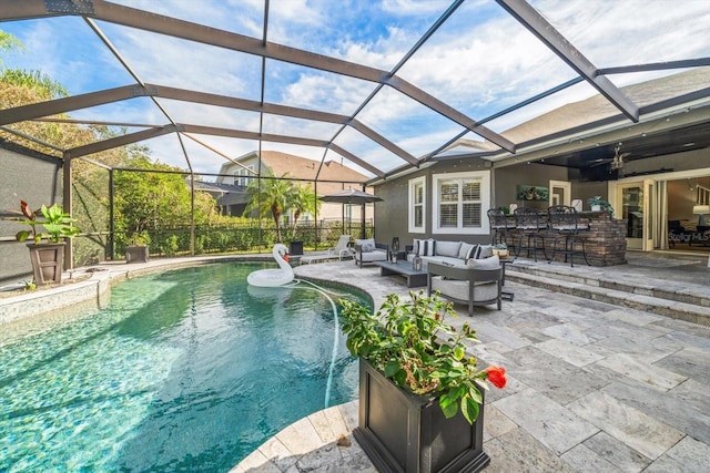 view of swimming pool featuring outdoor lounge area, pool water feature, ceiling fan, a bar, and a patio area