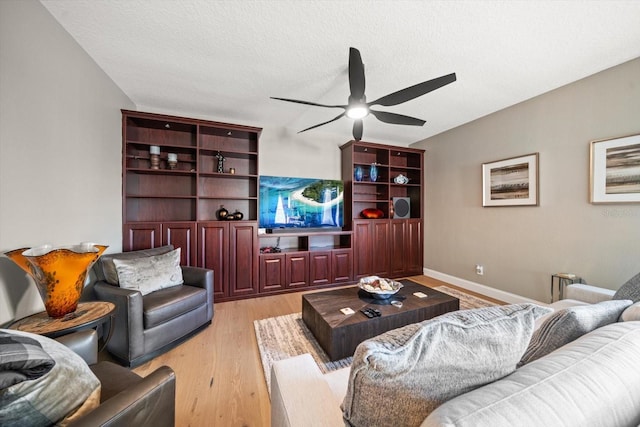 living room featuring a textured ceiling, light hardwood / wood-style floors, and ceiling fan