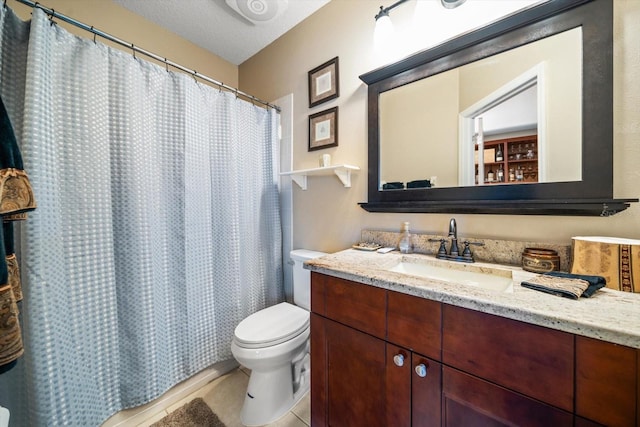 bathroom featuring tile patterned flooring, vanity, a textured ceiling, and toilet