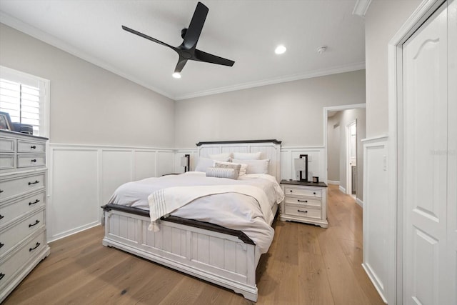 bedroom featuring ceiling fan, light wood-type flooring, and ornamental molding