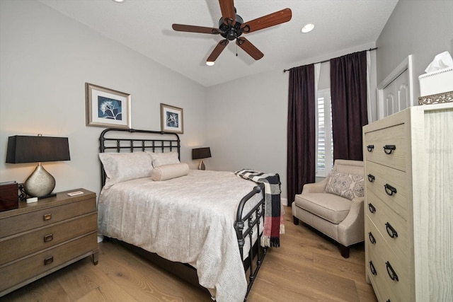 bedroom with ceiling fan, light wood-type flooring, and a closet