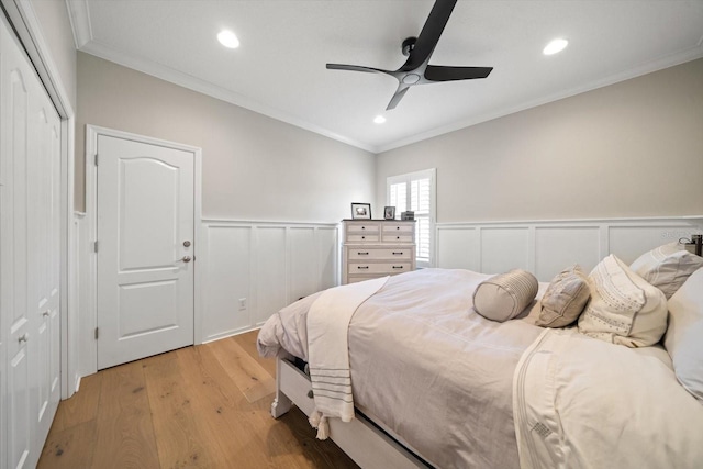 bedroom featuring ceiling fan, crown molding, and light hardwood / wood-style flooring